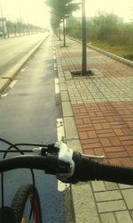 Cropped image of man riding bicycle on road