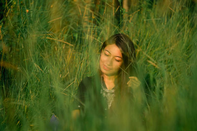 Young woman sitting amidst grass