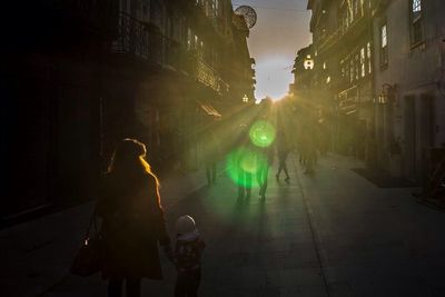 Woman standing on illuminated street at night