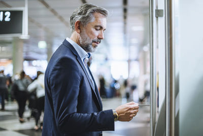 Businessman withdrawing money at an atm in the city