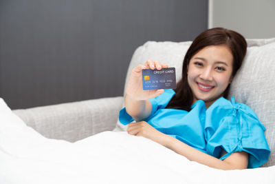 Portrait of smiling young woman lying on bed