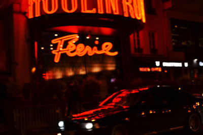 Illuminated sign on street in city at night