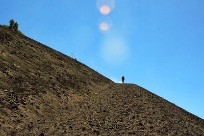 Low angle view of people against blue sky