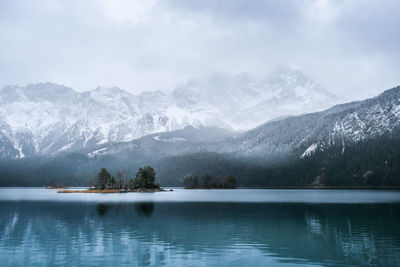 Scenic view of lake by mountains against sky