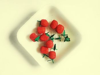 Close-up of red berries on white background