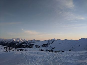 Scenic view of snowcapped mountains against sky during sunset