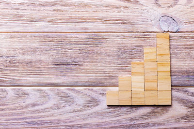 A wooden blocks cube over black wooden textured background with copy space 