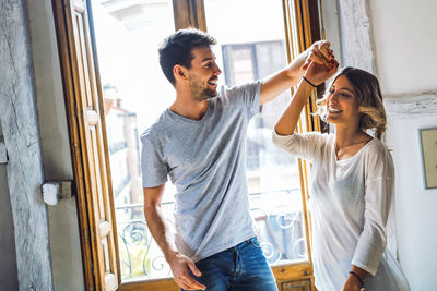 Young man and woman standing by window