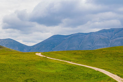 Scenic view of landscape and mountains against sky in castelluccio, umbria 