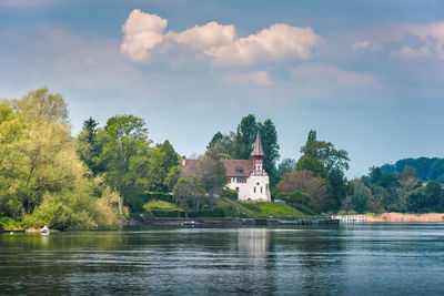 Scenic view of lake by building against sky