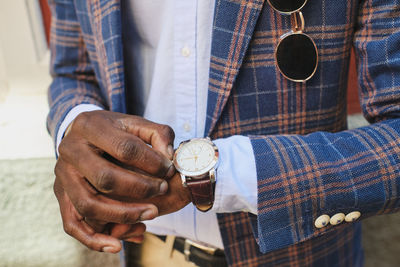 Midsection of man holding clock