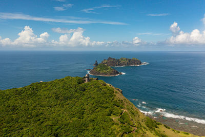 Lighthouse on a cape against the backdrop of tropical islands and blue sky. cape engano. 