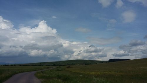 Scenic view of field against cloudy sky