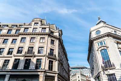 Low angle view of old buildings in regent street in london against blue sky