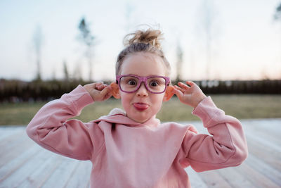 Portrait of cute girl with pink standing outdoors