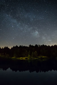 Scenic view of lake against sky at night