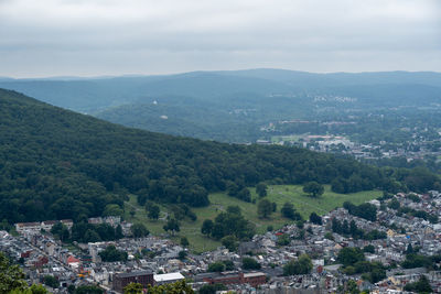 Aerial view of townscape and mountains against sky