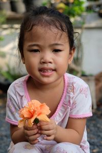 Portrait of cute girl holding flower