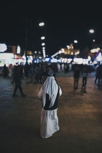 Low section of person standing on road by garbage bin