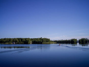 Scenic view of lake against clear blue sky