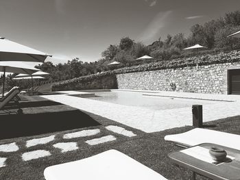 Shadow of tree by swimming pool against sky