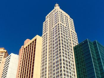 Low angle view of modern building against clear blue sky