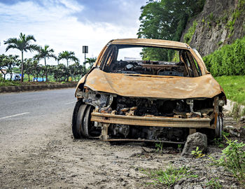 Abandoned burnt car remains on the side of the road