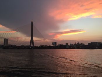 View of suspension bridge in city at sunset