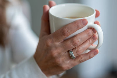 Midsection of woman holding coffee cup