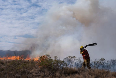 Man standing by bonfire on land