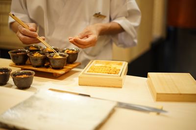 Midsection of chef preparing food on table