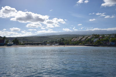 Scenic view of sea by town against sky