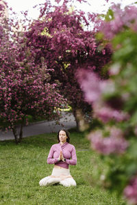 Woman with hands clasped meditating in garden