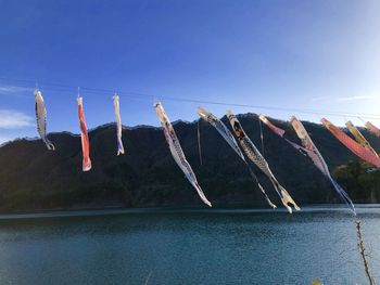 Low angle view of clothes drying against clear blue sky