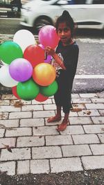 Full length portrait of a girl holding balloons