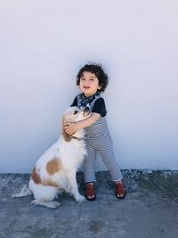 Portrait of boy with dog against sky