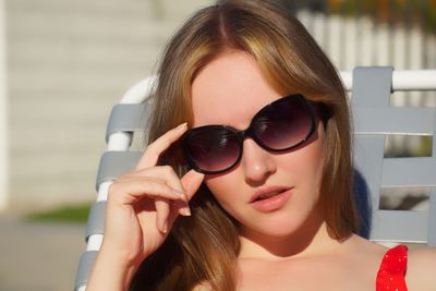 Close-up portrait of young woman in sunglasses