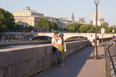 Woman with umbrella on bridge in city