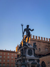 Low angle view of angel statue against clear blue sky