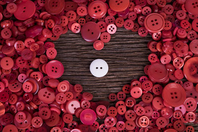Full frame shot of buttons arranged in heart shape on table 