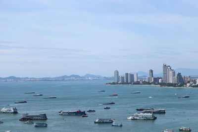 Boats in sea against buildings in city