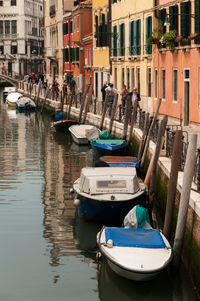 Boats moored in canal in city