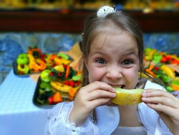 Portrait of girl eating muskmelon at home