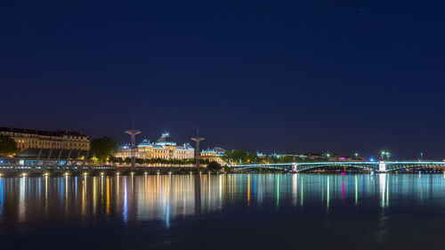 Reflection of illuminated lights on river at night