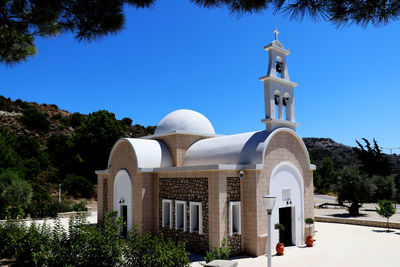 View of white building against clear blue sky