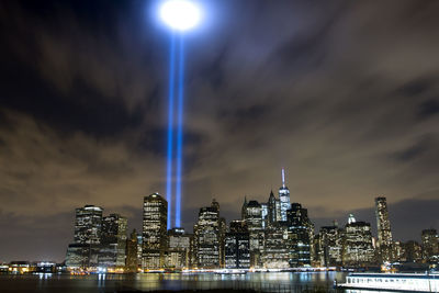 Low angle view of illuminated cityscape and tribute in light at night