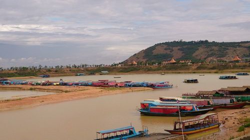 Boats moored at harbor against sky