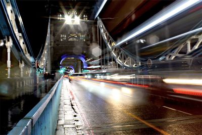 Light trails on bridge in city at night