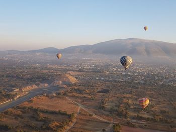 Hot air balloons flying over ancient pyramid