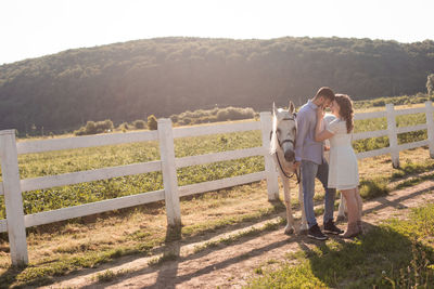 Couple standing on railing against mountain